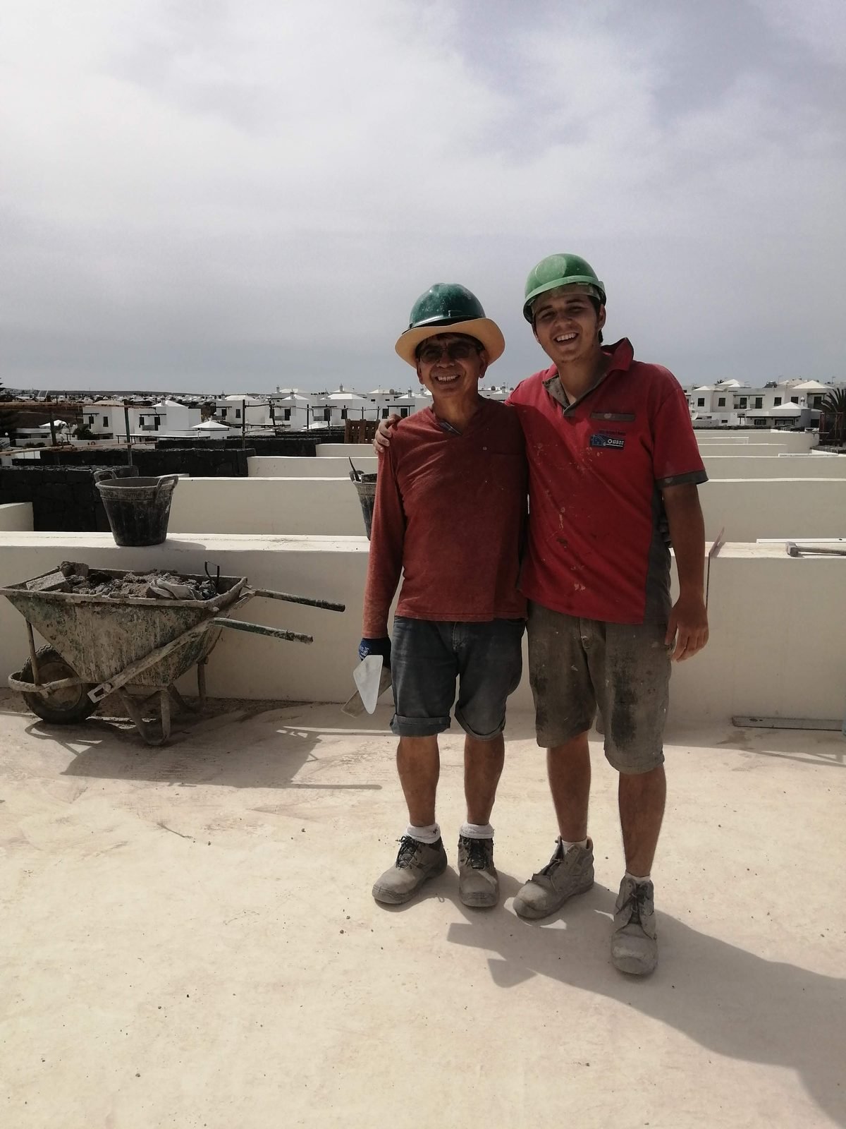 Dos generaciones de la familia de Terraform durante una obra de albañilería en una cubierta en Lanzarote